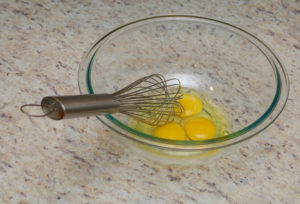 Egg and whisk on counter